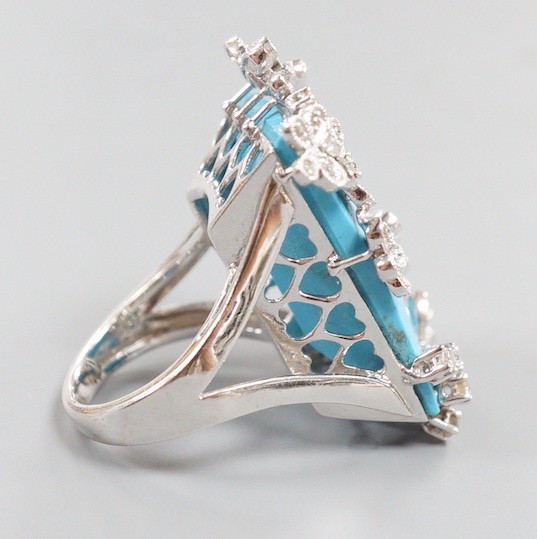 A large modern 14k white metal, turquoise and diamond chip set dress ring, the rectangular 'chequerboard' top cut turquoise weighing approx. 18.25ct, size M, gross weight 15 grams.